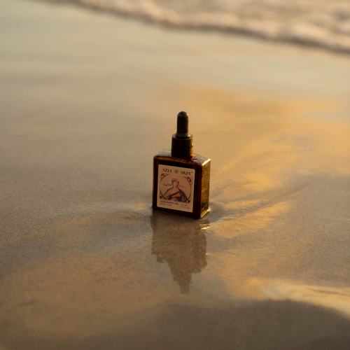 Small bottle with a label on a sandy surface